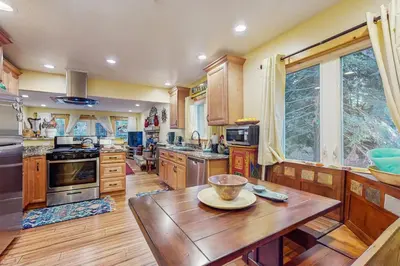 a large kitchen with wooden cabinets and a wooden table at Colorado Pines Retreat in South Lake Tahoe