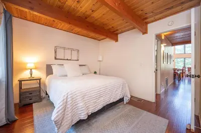 a bedroom with a large bed and a wooden ceiling at Arnold A Frame Cabin with Hot Tub and Guest Suite in Arnold