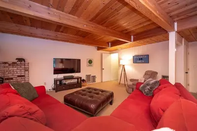 a living room with a red couch and a tv at Arnold A Frame Cabin with Hot Tub and Guest Suite in Arnold