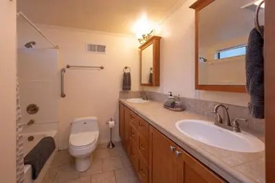 a bathroom with a toilet and a sink and a mirror at Arnold A Frame Cabin with Hot Tub and Guest Suite in Arnold
