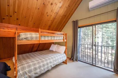 a bedroom with two bunk beds and a large window at Arnold A Frame Cabin with Hot Tub and Guest Suite in Arnold