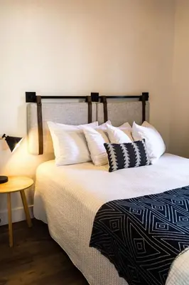 a bedroom with a bed with white pillows and a lamp at Yosemite Cottage Retreat- Half Block to Downtown in Mariposa