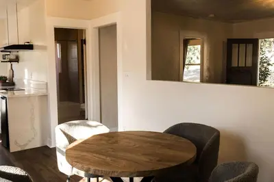 a table and chairs in a kitchen with a mirror at Yosemite Cottage Retreat- Half Block to Downtown in Mariposa