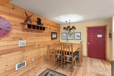 a dining room with a red door and wooden walls at Chamonix #15 - Cozy Mtn Retreat with Fireplace in Mammoth Lakes