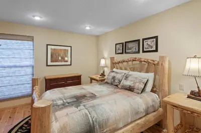 a bedroom with a wooden bed and a window at Chamonix #15 - Cozy Mtn Retreat with Fireplace in Mammoth Lakes