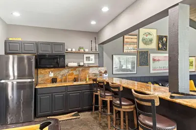 a kitchen with a bar with stools and a refrigerator at Chamonix #15 - Cozy Mtn Retreat with Fireplace in Mammoth Lakes