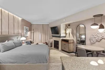 a bedroom with a bed and a living room at Hillside #508 - Cozy Studio w King Bed Fireplace & Kitchenette in Mammoth Lakes