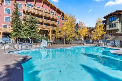 a large swimming pool in front of a building at The Village #2408 - Village Center Cozy Getaway w Fireplace in Mammoth Lakes