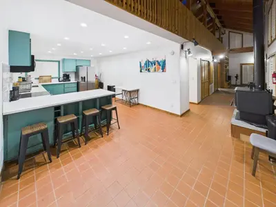 a kitchen with a counter and stools in a room at Hilltop Luxury Yosemite Retreat with Spa, Pool, Views in Mariposa