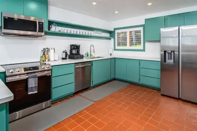 a kitchen with green cabinets and stainless steel appliances at Hilltop Luxury Yosemite Retreat with Spa, Pool, Views in Mariposa