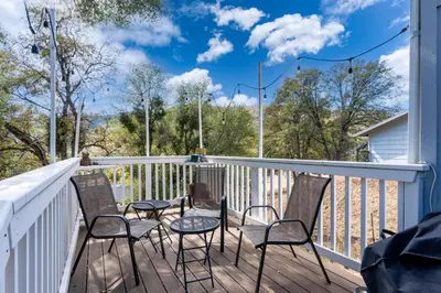 a deck with four chairs and a table on it at Yosemite Terrace View Retreat in Mariposa