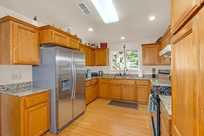 a kitchen with wooden cabinets and a stainless steel refrigerator at Yosemite Terrace View Retreat in Mariposa