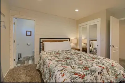 a bedroom with a bed with a comforter on it at Hillside Bungalow - Walking distance to downtown in Mariposa