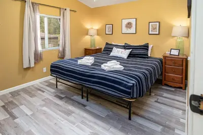 a bedroom with a bed with two towels on it at The Nest-2 K Beds-Game Room-Deck-5 min to Mariposa in Mariposa