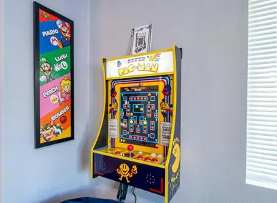 a yellow video game machine next to a wall at The Nest-2 K Beds-Game Room-Deck-5 min to Mariposa in Mariposa