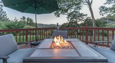 a table with a fire pit on a deck at Sullivan House & SPA Near Yosemite, 8 Min to Town in Mariposa