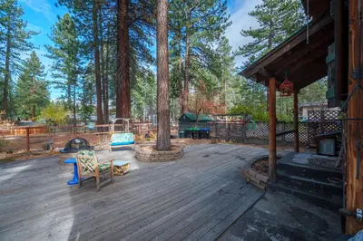 a wooden deck with trees and a fire place at Tahoe Heavenly Hideaway 1060H in South Lake Tahoe