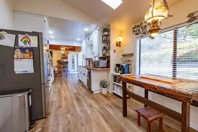 a kitchen with a wooden table and a refrigerator at Kindred Spirits Lodge near Yosemite & Bass Lake! in Oakhurst