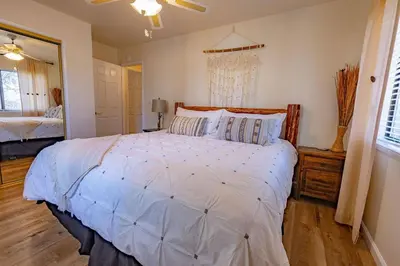 a bedroom with a large bed with a white comforter at Kindred Spirits Lodge near Yosemite & Bass Lake! in Oakhurst