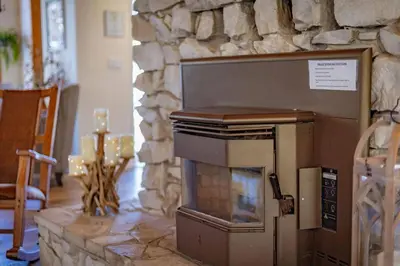 a stone fireplace in a room with a stone wall at Kindred Spirits Lodge near Yosemite & Bass Lake! in Oakhurst