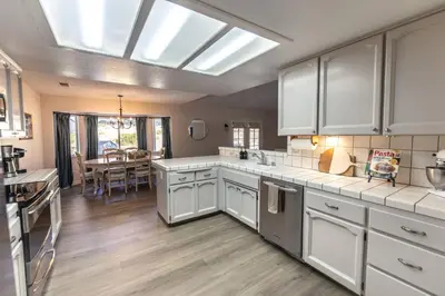 a large kitchen with white cabinets and a skylight at Moonrise Retreat, SPA, Near Yosemite & Bass Lake in Oakhurst