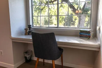 a chair sitting in front of a window at Moonrise Retreat, SPA, Near Yosemite & Bass Lake in Oakhurst