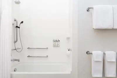a white bathroom with a shower and a tub and towels at Holiday Inn Express & Suites Sparks Reno East by IHG in Sparks