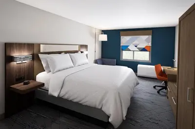 a bedroom with a large white bed and a desk at Holiday Inn Express & Suites Sparks Reno East by IHG in Sparks