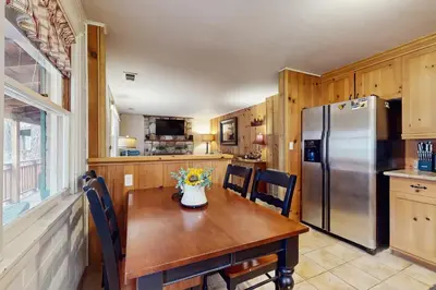 a kitchen with a wooden table and a refrigerator at Basecamp on Aspen in South Lake Tahoe