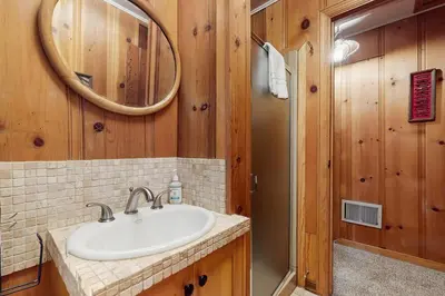 a bathroom with a sink and a mirror and a shower at Basecamp on Aspen in South Lake Tahoe