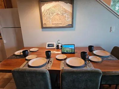 a wooden table with plates and utensils on it at Heavenly Stagecoach Ski Retreat in Stateline