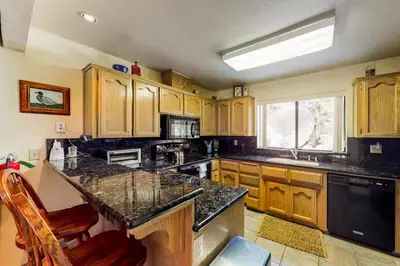 a kitchen with wooden cabinets and a black counter top at Eagle's Nest in Big Creek