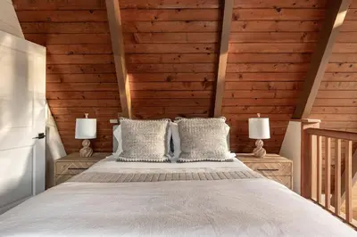 a bedroom with a bed with wooden walls at Acorn Falls, Bass Lake, Ca in Bass Lake