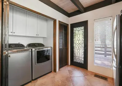 a kitchen with a washer and dryer next to a door at Boss's Cabin - Boss-level views, zero stress! in Shaver Lake