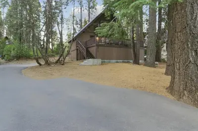 a house in the woods with a driveway at Boss's Cabin - Boss-level views, zero stress! in Shaver Lake
