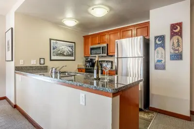 a kitchen with a counter and a refrigerator at Village 1209 in Mammoth Lakes