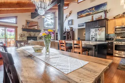 a kitchen with a large wooden table with flowers on it at Boathouse in the Woods by Tahoe Getaways - Minutes to Lake Tahoe & Northstar in Kings Beach