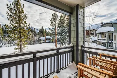 a balcony with a view of a snow covered yard at Mammoth Green - 207 in Mammoth Lakes