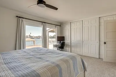 a bedroom with a bed and a view of the ocean at 5 Min to Fast Water Waterfront Discovery Bay Home in Discovery Bay