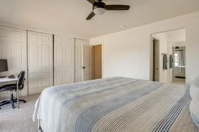a white bedroom with a bed and a desk at 5 Min to Fast Water Waterfront Discovery Bay Home in Discovery Bay