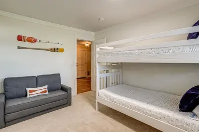 a bedroom with two bunk beds and a couch at 5 Min to Fast Water Waterfront Discovery Bay Home in Discovery Bay