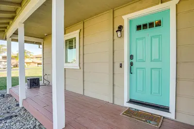 a house with a blue door on a porch at 5 Min to Fast Water Waterfront Discovery Bay Home in Discovery Bay