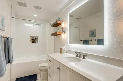 a bathroom with a sink and a toilet and a mirror at 5 Min to Fast Water Waterfront Discovery Bay Home in Discovery Bay