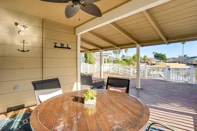 a patio with a wooden table and chairs on a deck at 5 Min to Fast Water Waterfront Discovery Bay Home in Discovery Bay