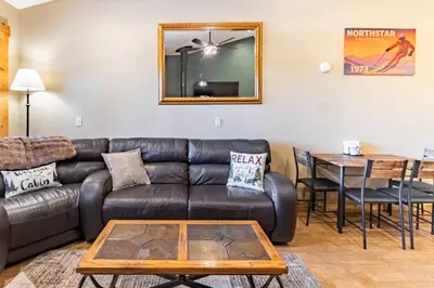 a living room with a leather couch and a table at Northstar Resort 2BR Condo with Rec Center Access in Truckee