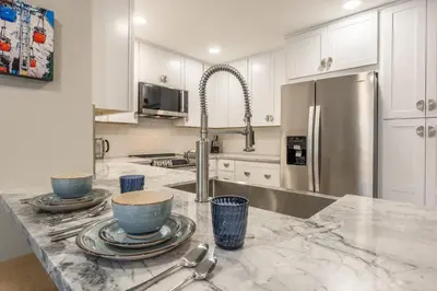 a kitchen with white cabinets and a marble counter top at Snowcreek IV 559 in Mammoth Lakes