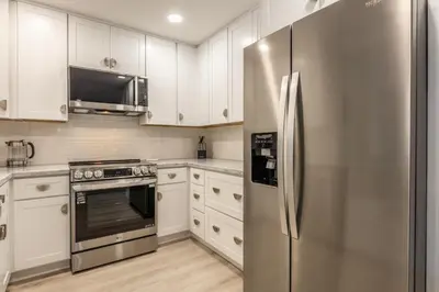 a kitchen with white cabinets and a stainless steel refrigerator at Snowcreek IV 559 in Mammoth Lakes