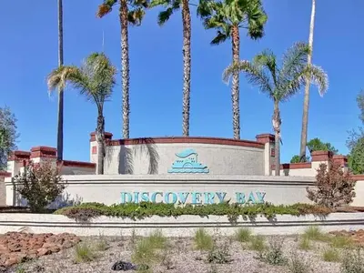 a sign in front of aocococo bay with palm trees at 3 Bedrooms - Game Room - On the water in Discovery Bay