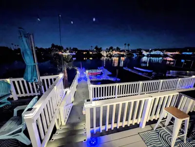 a deck with a view of a marina at night at 3 Bedrooms - Game Room - On the water in Discovery Bay
