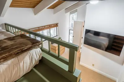 a bedroom with a staircase leading to a bed and a window at St Moritz 38 in Mammoth Lakes
